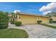 Front view of a yellow house with a two-car garage and landscaped yard at 7146 Lakeside Dr, Sarasota, FL 34243