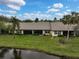 Single-story villa with a canal view, featuring a tiled roof and lush landscaping at 7146 Lakeside Dr, Sarasota, FL 34243