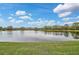 Peaceful lake view with lush green landscaping and clear blue skies at 7146 Lakeside Dr, Sarasota, FL 34243