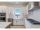 Modern white kitchen with stainless steel appliances and lake views at 7420 Newham Ln, Sarasota, FL 34240