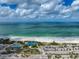 Aerial view of beach with parking lot, lifeguard stand and people enjoying the sun at 800 S Blvd Of Presidents # 12, Sarasota, FL 34236
