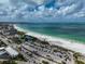 Aerial view of beach with parking lot, lifeguard stand and people enjoying the sun at 800 S Blvd Of Presidents # 12, Sarasota, FL 34236