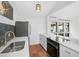 Modern kitchen with white cabinets, stainless steel appliances, and tile floors at 800 S Blvd Of Presidents # 12, Sarasota, FL 34236