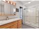 Bathroom with light wood cabinets, marble countertop, and a large walk-in shower at 829 Harbor S Dr, Venice, FL 34285