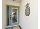 Front entry with teal door, pineapple decor, and welcome mat at 829 Harbor S Dr, Venice, FL 34285