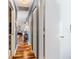 Long hallway with wood flooring and blue walls, leading to the living room at 829 Harbor S Dr, Venice, FL 34285