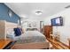 Main bedroom with king bed, wood floors, and a large TV at 829 Harbor S Dr, Venice, FL 34285