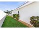 Landscaped side yard with grassy area and shrubs at 829 Harbor S Dr, Venice, FL 34285