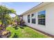 Landscaped side yard with grassy area and tropical plants at 829 Harbor S Dr, Venice, FL 34285
