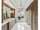 Bathroom featuring marble floors, dual vanities, and a door leading to the outdoor patio at 8388 Catamaran Cir, Lakewood Ranch, FL 34202