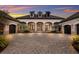 Elegant home featuring a beautiful stone driveway leading to a grand entrance with three-car garages on each side at 8388 Catamaran Cir, Lakewood Ranch, FL 34202