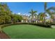 Manicured front lawn featuring meticulously landscaped bushes, trees and a view of the home's entrance at 8388 Catamaran Cir, Lakewood Ranch, FL 34202