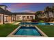 Twilight view of a private pool, spa, and landscaped backyard with covered outdoor living area at 8388 Catamaran Cir, Lakewood Ranch, FL 34202