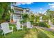 White two story building with balconies, lush landscaping, and white Adirondack chairs at 866 Hudson Ave # 866, Sarasota, FL 34236