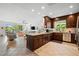 Open concept kitchen with granite island, dark wood cabinets, and tile flooring at 866 Hudson Ave # 866, Sarasota, FL 34236