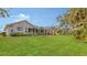 Spacious backyard with lush green lawn and a screened patio at 872 Clear Lake Dr, Englewood, FL 34223
