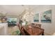 Well-lit dining room with wooden table, and view into adjacent living room at 872 Clear Lake Dr, Englewood, FL 34223