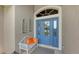 Inviting entryway with a blue door, white bench, and decorative accents at 872 Clear Lake Dr, Englewood, FL 34223
