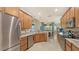 Well-equipped kitchen with granite counters, stainless steel appliances, and wood cabinets at 872 Clear Lake Dr, Englewood, FL 34223