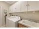 Laundry room with washer, dryer, cabinets, and utility sink at 872 Clear Lake Dr, Englewood, FL 34223