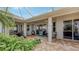 Covered patio with brick pavers and lush landscaping at 872 Clear Lake Dr, Englewood, FL 34223