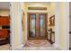 Elegant entryway with double glass doors, tile flooring, and columns at 8808 Enclave Ct, Sarasota, FL 34238