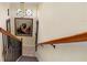 Grand staircase with wood railing and large artwork at 8808 Enclave Ct, Sarasota, FL 34238