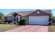 One-story home with attached garage, neat landscaping, and a red driveway at 114 Wilmers Rd, Punta Gorda, FL 33982