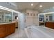 Elegant bathroom with soaking tub, granite vanity, and tiled floors at 1225 S View Dr, Sarasota, FL 34242