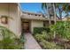 Welcoming entryway with a brick walkway, lush greenery, and a modern door at 1225 S View Dr, Sarasota, FL 34242