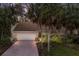 Brick driveway leads to a single-story home with a large garage, surrounded by lush landscaping at 1225 S View Dr, Sarasota, FL 34242