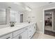 Double vanity bathroom with white cabinets, quartz countertops, and walk-in closet at 12409 Wigeon Dr, Bradenton, FL 34212