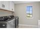 Laundry room with modern washer and dryer, and overhead cabinets at 12409 Wigeon Dr, Bradenton, FL 34212