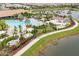 Expansive lagoon-style pool with surrounding lounge chairs and landscaping at 12410 Osorio Ct # 103, Sarasota, FL 34238