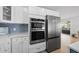 Modern kitchen features white cabinets and stainless steel appliances at 127 Crescent Dr, Anna Maria, FL 34216