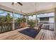 Screened porch with wooden swings and a view of palm trees at 127 Crescent Dr, Anna Maria, FL 34216