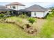 Home exterior showcasing a screened lanai and lush landscaping at 13153 Steinhatchee Loop, Venice, FL 34293