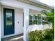 Navy blue front door with glass inserts and white columns at 13153 Steinhatchee Loop, Venice, FL 34293