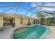 Relaxing kidney-shaped pool with screened enclosure & patio at 1572 Nimbus Dr, North Port, FL 34287