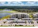 Aerial view of a modern apartment building with parking and a golf course nearby at 18114 Gawthrop Dr # 404, Bradenton, FL 34211