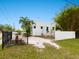 Charming bungalow with a white exterior, landscaped yard, and black metal fence at 202 27Th W St, Bradenton, FL 34205