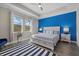 Main bedroom with blue accent wall and a comfortable king-size bed at 2028 Woodleaf Hammock Ct, Bradenton, FL 34211