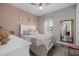 Charming bedroom with a blush pink accent wall and cozy bedding at 2028 Woodleaf Hammock Ct, Bradenton, FL 34211