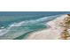 Aerial view of a sandy beach with ocean waves and people at 203 72Nd St, Holmes Beach, FL 34217