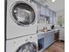 Stackable washer and dryer in a small laundry room with gray cabinets at 203 72Nd St, Holmes Beach, FL 34217