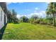 Large grassy backyard with lush landscaping at 2133 Selover Rd, North Port, FL 34287