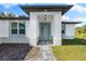 Modern front entrance with gray door, paver walkway, and landscape at 2133 Selover Rd, North Port, FL 34287