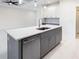 Kitchen island with white quartz countertop and gray cabinets at 2133 Selover Rd, North Port, FL 34287