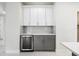 Modern wet bar with wine cooler and gray cabinets at 2133 Selover Rd, North Port, FL 34287