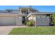 Exterior view of two-story home with landscaped yard and two car garage at 2195 Harbourside Dr # 404, Longboat Key, FL 34228